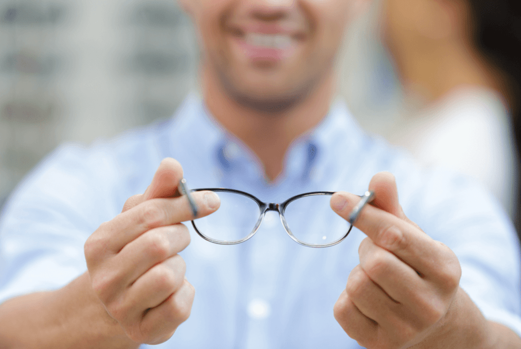 Question sur les verres progressifs, mains d'un opticien tenant des lunettes pour illustrer les verres progressifs